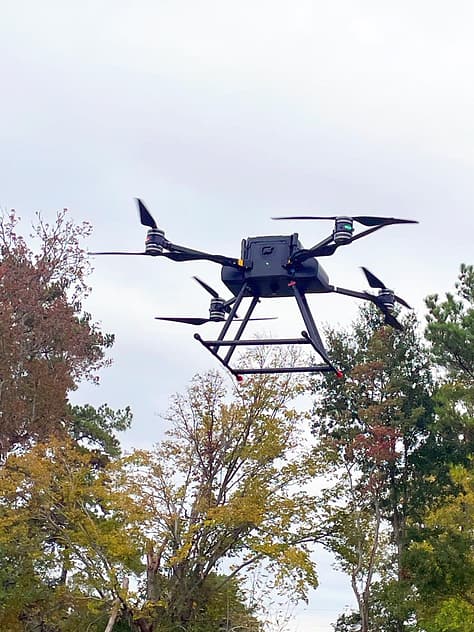 Drone flying over trees on a cloudy day